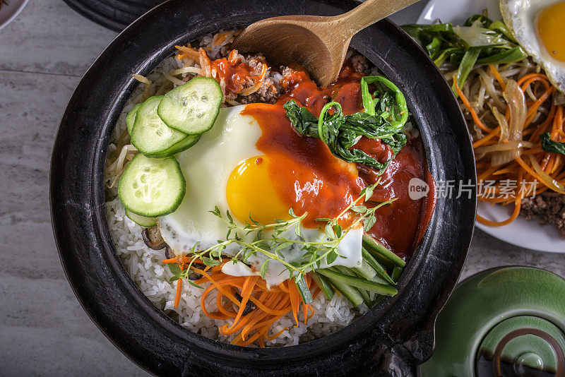 BI Bim Bap，拌菜饭，顶视图与热酱在铸铁锅